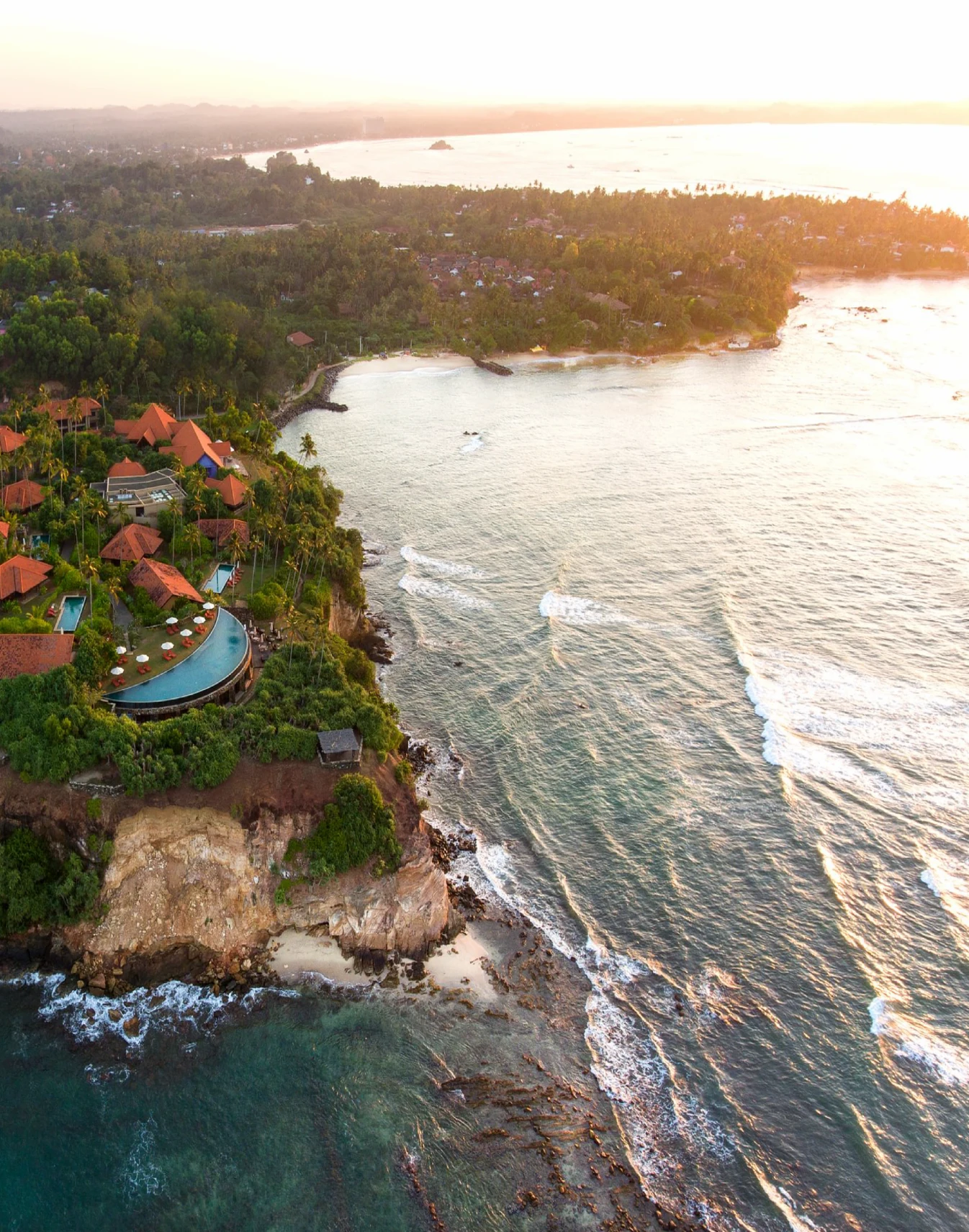 Drone shot of the ocean with houses on the land